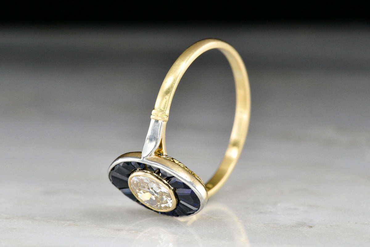Early 1900s Gold and Platinum Ring with Calibré Cut Sapphires and an Old European Cut Diamond Center