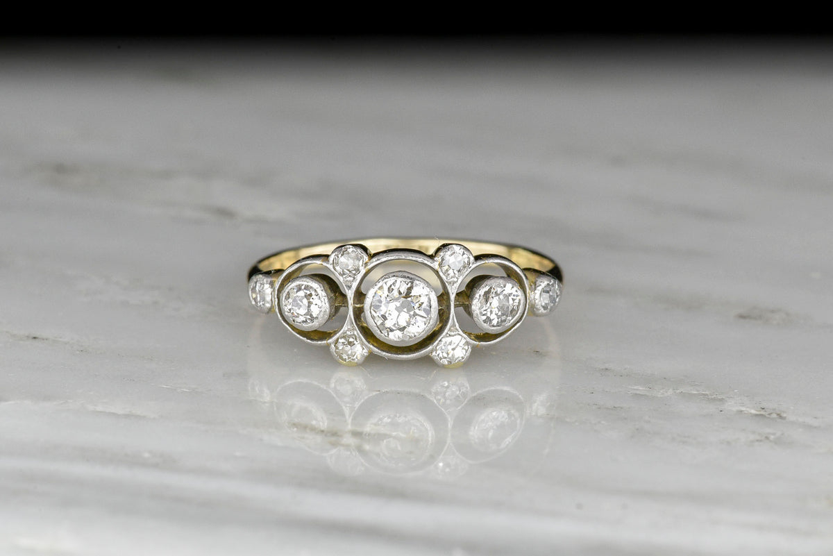 Belle Époque Gold and Platinum Ring with a Unique Floating Three-Stone Bezel Design