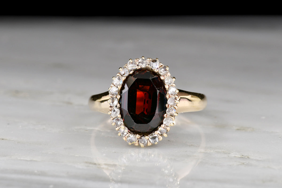c. 1900 Victorian Ring with an Oval Garnet and Antique Rose Cut Diamond Surround