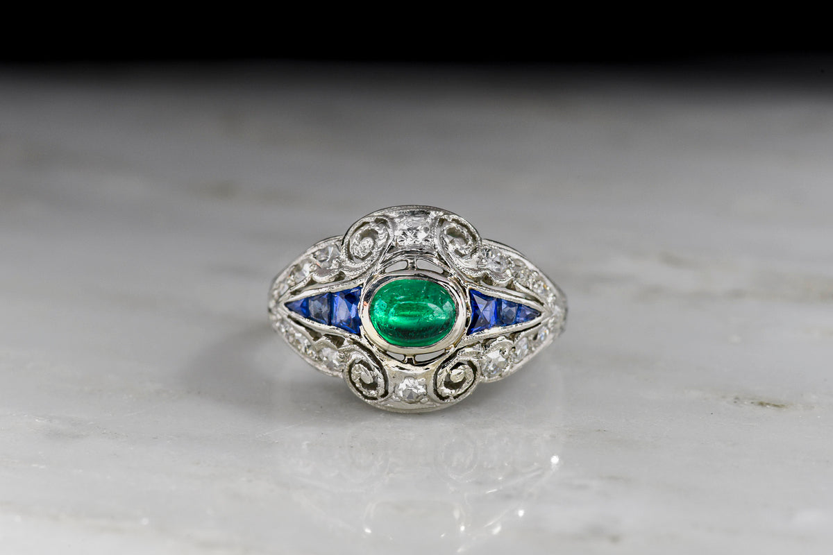 Art Deco Dinner Ring with an Emerald Center, Sapphire Sides, and Diamond Surround